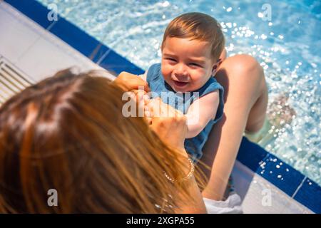 Vista dall'alto primo piano di una madre caucasica con un bambino in piscina Foto Stock