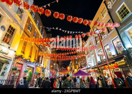 Gente in via Gerrard decorata con lanterne rosse cinesi, Chinatown di notte a Londra, Regno Unito Foto Stock