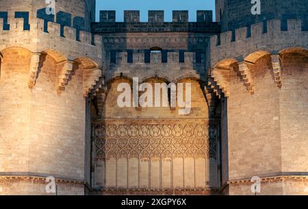 Primo piano delle Torri Serranos di Valencia, in Spagna, illuminate di notte. I dettagli architettonici e l'illuminazione creano un'atmosfera storica e maestosa. Foto Stock