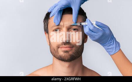 Uomo che riceve l'iniezione della fronte Foto Stock