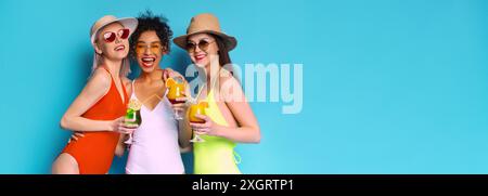 Tre amici che si godono un cocktail estivo su sfondo blu Foto Stock