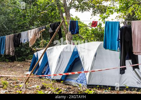 I campeggiatori asciugano i vestiti con la fila al campeggio accanto alla tenda Foto Stock