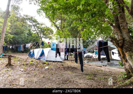 I campeggiatori asciugano i vestiti con la fila al campeggio accanto alla tenda Foto Stock