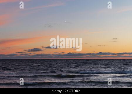 Mare in Estonia durante le onde dopo il tramonto in estate. Foto Stock