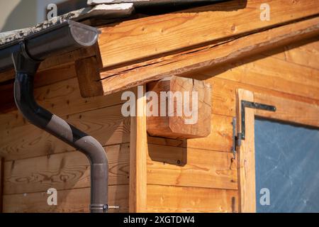 tetto con travi in legno, con la posizione del tubo di scarico e delle grondaie. il tetto e le travi di legno a vista rendono l'edificio molto più bello. Foto Stock