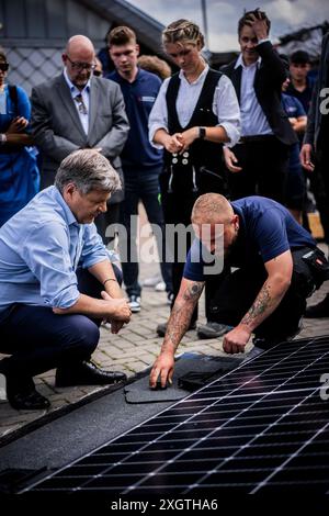 Bochum, Deutschland. 10 luglio 2024. Il ministro federale dell'economia e della protezione del clima Robert Habeck (Alleanza 90/Verdi) in un viaggio estivo attraverso la Germania. Qui a Bochum, 10 luglio 2024, visita un conciatetto con elementi del tetto solare. Fotografato per conto di BMWK/dpa/Alamy Live News Foto Stock