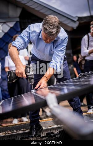 Bochum, Deutschland. 10 luglio 2024. Il ministro federale dell'economia e della protezione del clima Robert Habeck (Alleanza 90/Verdi) in un viaggio estivo attraverso la Germania. Qui a Bochum, 10 luglio 2024, visita un conciatetto con elementi del tetto solare. Fotografato per conto di BMWK/dpa/Alamy Live News Foto Stock