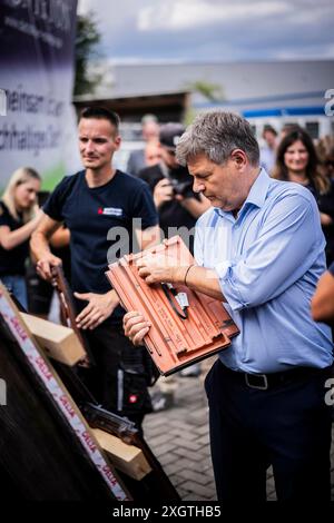 Bochum, Deutschland. 10 luglio 2024. Il ministro federale dell'economia e della protezione del clima Robert Habeck (Alleanza 90/Verdi) in un viaggio estivo attraverso la Germania. Qui a Bochum, 10 luglio 2024, visita un conciatetto con elementi del tetto solare. Fotografato per conto di BMWK/dpa/Alamy Live News Foto Stock