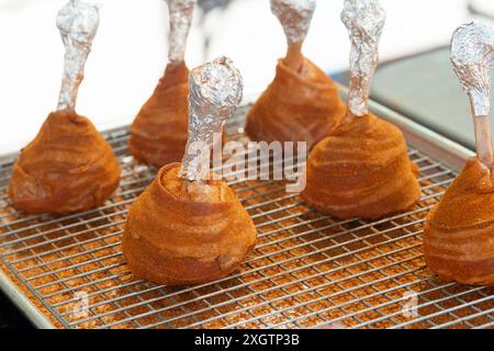 Avvolge le cosce di pollo di lecca lecca-lecca in pancetta Foto Stock