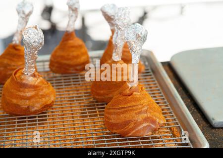 Avvolge le cosce di pollo di lecca lecca-lecca in pancetta Foto Stock