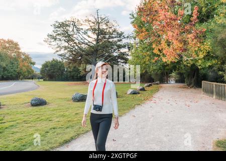 Bella donna asiatica che cammina e si fa esercizio nel parco autunnale di Cornwall Park, Auckland, nuova Zelanda Foto Stock