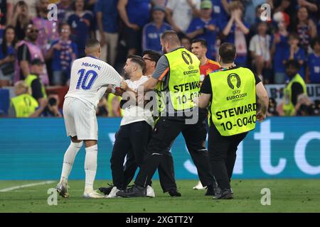 Monaco, Germania. 9 luglio 2024. Kylian Mbappe di Francia reagisce come steward che trattano con un invasore di campo che tenta di fare un selfie con l'attaccante del Frnench durante la semifinale dei Campionati europei UEFA all'Allianz Arena di Monaco. Il credito per immagini dovrebbe essere: Jonathan Moscrop/Sportimage Credit: Sportimage Ltd/Alamy Live News Foto Stock