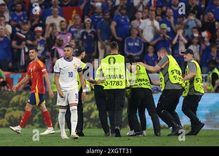 Monaco, Germania. 9 luglio 2024. Kylian Mbappe di Francia reagisce come steward che trattano con un invasore di campo che tenta di fare un selfie con l'attaccante del Frnench durante la semifinale dei Campionati europei UEFA all'Allianz Arena di Monaco. Il credito per immagini dovrebbe essere: Jonathan Moscrop/Sportimage Credit: Sportimage Ltd/Alamy Live News Foto Stock