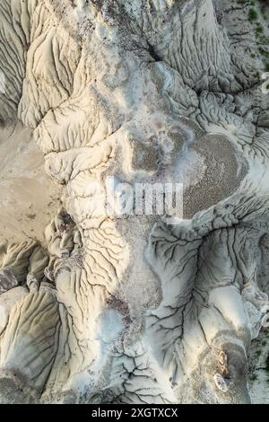 Uno scatto aereo che cattura la complessa superficie strutturata delle Badlands di Bisti, caratterizzata da strati e forme modellate dall'erosione naturale Foto Stock