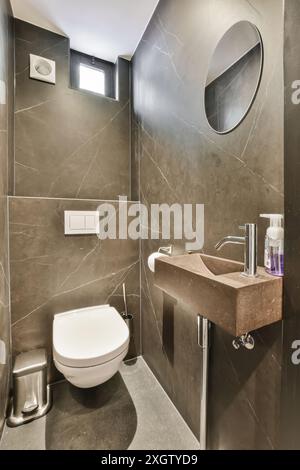 Bagno elegante e moderno con piastrelle in marmo grigio, elegante lavabo e finiture eleganti situato a Hilversumstraat, Amsterdam, miscela perfetta di lu Foto Stock