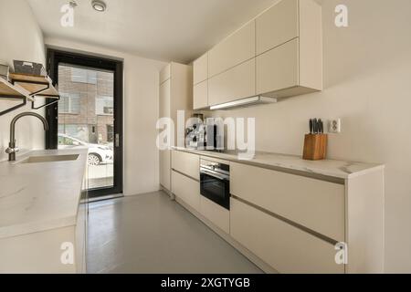 Elegante cucina moderna con mobili bianchi e ripiani in marmo, situata in Jan Vrijmanstraat 98. La cucina include elettrodomestici di alta qualità e. Foto Stock