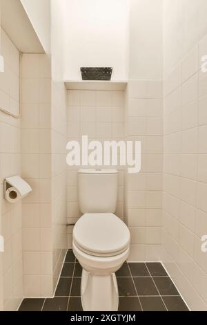 Bagno minimalista con WC bianco su pareti piastrellate di beige, accentuato da piastrelle scure, a Joan Melchior Kemperstraat, Amsterdam Foto Stock