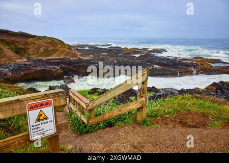 Cartello di avvertenza di sicurezza costiera resistente con movimento delle onde in collisione Foto Stock