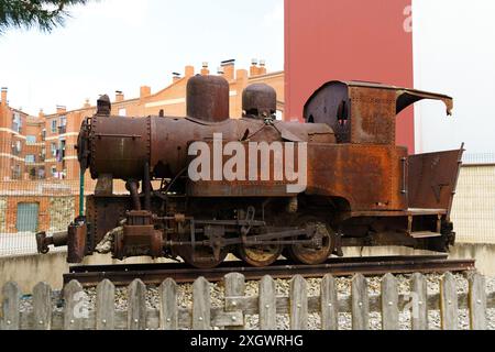 Un treno arrugginito abbandonato sulla cima di un binario ferroviario, che mostra il decadimento e l'abbandono delle infrastrutture di trasporto. Foto Stock