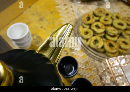 Vista dall'alto per la mancia della caffettiera araba e i dolci eid con tazze sullo sfondo su un tavolo di legno Foto Stock