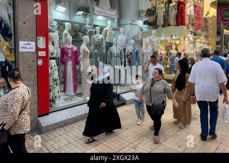 Cairo, Egitto. 10 luglio 2024. La gente passa davanti a un negozio di abbigliamento al Cairo, in Egitto, il 10 luglio 2024. Il tasso d'inflazione annuale principale dell'Egitto è sceso al 27,1% a giugno, in calo dal 27,4% di maggio, continuando una tendenza al ribasso per il quarto mese consecutivo, l'organo statistico del paese ha riferito mercoledì. Crediti: Ahmed Gomaa/Xinhua/Alamy Live News Foto Stock
