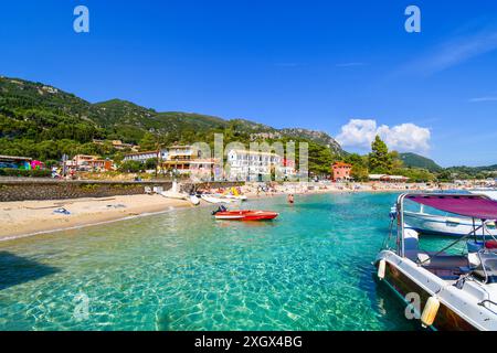 La spiaggia sabbiosa e il villaggio sul mare di Palaiokastritsa, sull'isola egea di Corfù, in Grecia. Foto Stock