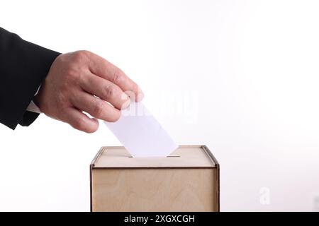 Uomo che mette il suo voto nelle urne su sfondo bianco, primo piano Foto Stock