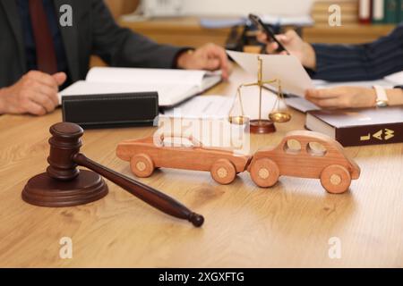 Auto di legno con martelletto del giudice sul tavolo dell'avvocato durante la riunione in ufficio, primo piano Foto Stock