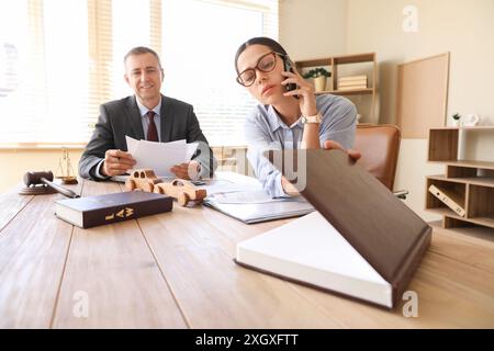 Avvocato donna che parla al telefono cellulare durante la riunione in ufficio Foto Stock