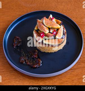 Appetitoso tartaruga di fichi seduta su un piatto con la marmellata di fichi spalmata lateralmente Foto Stock