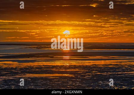 Guardando verso ovest il tramonto arancione sulle distese di marea del fiume normanno a Karumba, Golfo di Carpentaria, Queensland, Australia Foto Stock