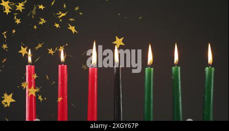 Immagine di stelle dorate che cadono sulle candele kwanzaa su sfondo nero. Il concetto di festa, celebrazione e tradizione Kwanzaa è un'immagine generata digitalmente Foto Stock