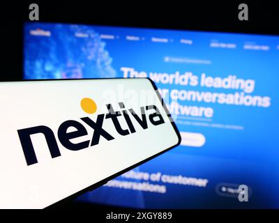 Telefono cellulare con logo della società americana di software di comunicazione Nextiva Inc. Davanti al sito Web. Mettere a fuoco la parte centrale sinistra del display del telefono. Foto Stock