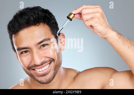 Cura della pelle, ritratto dell'uomo o del siero in studio per il trattamento, olio di avocado o prodotto anti invecchiamento. Persona maschile, pipetta o sorriso per le routine cutanee con Foto Stock