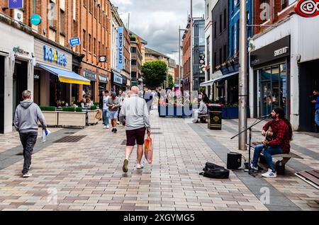 Belfast , Contea di Antrim Irlanda del Nord 05 luglio 2024 - Busker suona una chitarra esibendosi ad Ann Street Belfast City Centre Foto Stock