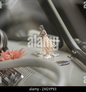 Un ornamento Hawaaiian Hula Girl sul cruscotto di un classico VW Bus a schermo diviso Foto Stock