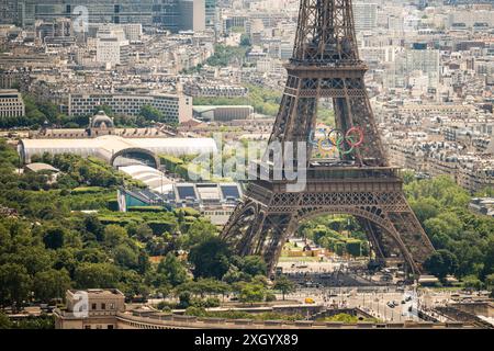 Parigi, Francia. 10 luglio 2024. Questa immagine aerea mostra la Torre Eiffel con gli anelli delle Olimpiadi di Parigi 2024 la costruzione sul campo di Marte per il Beach volley e il calcio cieco a Parigi, Francia, il 10 luglio 2024. I Giochi olimpici si svolgeranno in Francia dal 26 luglio all'11 agosto. Foto di Eliot Blondet/ABACAPRESS. COM credito: Abaca Press/Alamy Live News Foto Stock