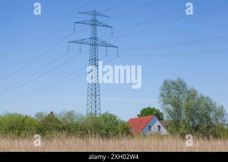 Edificio residenziale con piloni elettrici sul fiume Este, Buxtehude, bassa Sassonia, Germania Foto Stock