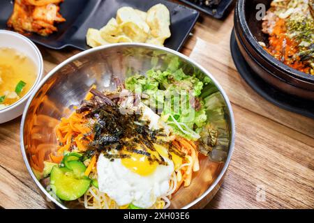 Bibimbap caldo. Riso misto con carne, uova fritte e verdure assortite. Il Bibimbap è un popolare piatto coreano. Foto Stock