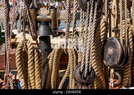 Linee di barche a vela, pulegge e attrezzature di sicurezza legate per la giornata. Ponte e funi, equipaggiati su uno yacht a vela in legno. Vista ravvicinata Foto Stock