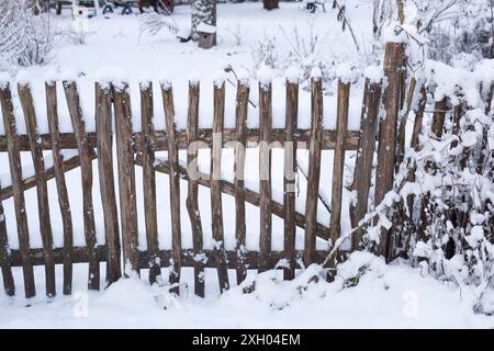 Recinzione da giardino coperta di neve con cancello da giardino in un giardino di riparto in inverno, Germania Foto Stock