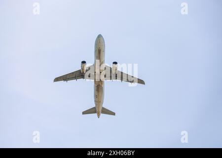 Aereo che vola nel cielo blu, vista dal basso. Aereo passeggeri in volo, concetto di viaggio Foto Stock