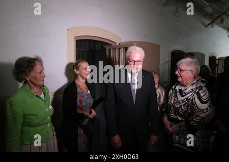 Stollberg, Germania. 11 luglio 2024. Il presidente federale Frank-Walter Steinmeier (M) è al fianco di testimoni contemporanei nell'ex carcere di Hoheneck. Nell'ex carcere femminile è stato aperto un monumento alle vittime della dittatura e della persecuzione. Il sito sarà aperto al pubblico da agosto 2024. Crediti: Sebastian Willnow/dpa/Alamy Live News Foto Stock