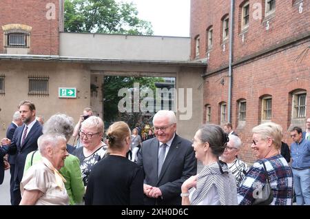 Stollberg, Germania. 11 luglio 2024. Il presidente federale Frank-Walter Steinmeier (M) si trova nel cortile dell'ex carcere di Hoheneck. Qui è stato aperto un monumento alle vittime della dittatura e della persecuzione. Il sito sarà aperto al pubblico da agosto 2024. Crediti: Sebastian Willnow/dpa/Alamy Live News Foto Stock