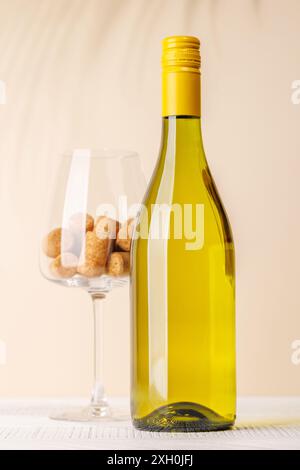 Bottiglia di vino bianco e bicchiere di vino con tappi di sughero. Con spazio di copia per il testo Foto Stock