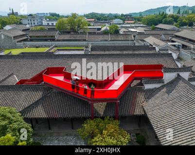 Ningbo. 9 luglio 2024. Una foto aerea scattata il 9 luglio 2024 mostra le persone che visitano un museo d'arte drammatica nell'antica contea di Cicheng nella città di Ningbo, nella provincia dello Zhejiang della Cina orientale. L'antica contea di Cicheng vanta una storia di 1.200 anni, dove edifici e strutture antiche coprono oltre 600.000 metri quadrati. Negli ultimi anni, la contea ha potenziato la sua economia turistica sfruttando i patrimoni culturali locali con servizi di accoglienza e ristorazione. La contea ha ricevuto circa 2,76 milioni di visitatori nel 2023. Crediti: Jiang Han/Xinhua/Alamy Live News Foto Stock