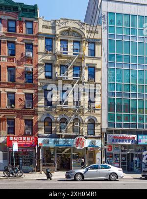 NYC Chinatown: Un tipico edificio di appartamenti in mattoni e terracotta sopra un negozio con cartello cinese, in una tranquilla mattinata nei giorni feriali. Foto Stock