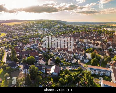 Veduta aerea di un fitto paesaggio urbano con case, strade e alberi circondati da colline e nuvole, Weil der Stadt, Germania Foto Stock