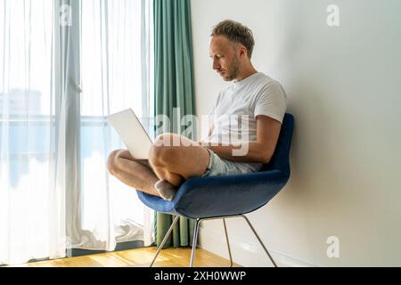 Uomo che lavora su un notebook in Bright Room. Foto Stock