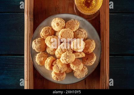 Amaretti, biscotti tradizionali italiani alle mandorle, con un bicchiere di liquore amaretto, top shot su fondo di legno blu scuro Foto Stock